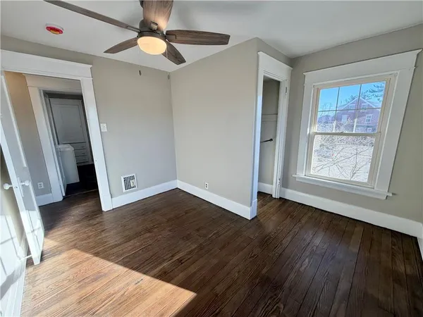 a view of a livingroom with wooden floor and a ceiling fan