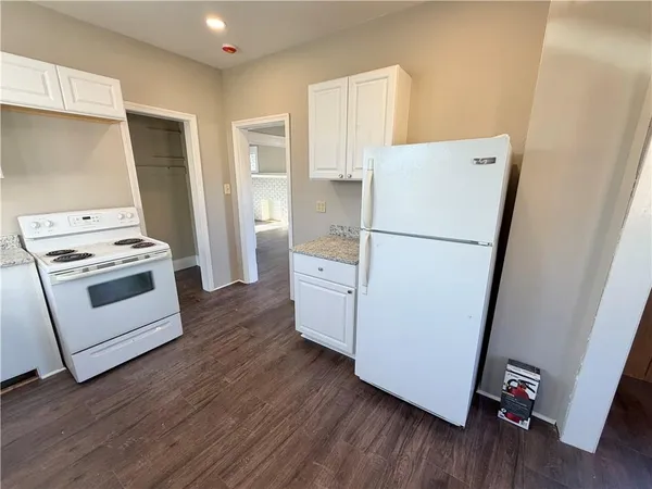 a white refrigerator freezer and a stove sitting inside of a kitchen