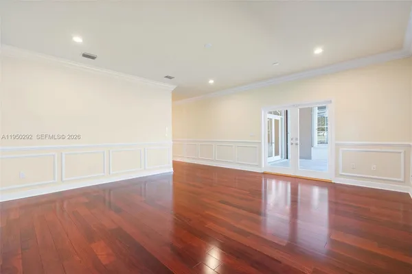 a view of empty room with wooden floor