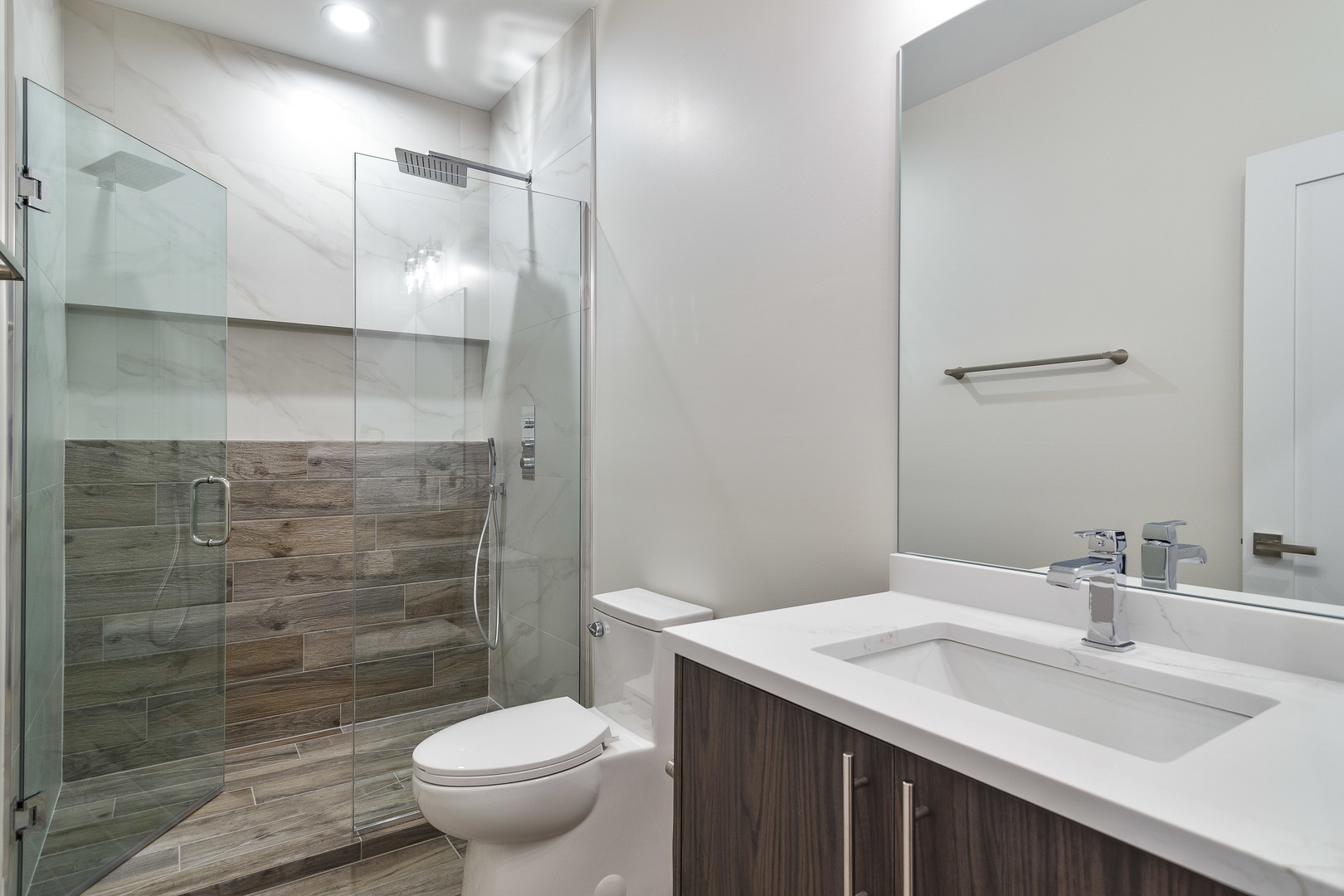 3013 North Normandy Avenue Chicago, IL 60634 - Photo 14 of 26 a bathroom with a granite countertop sink a toilet a mirror and shower