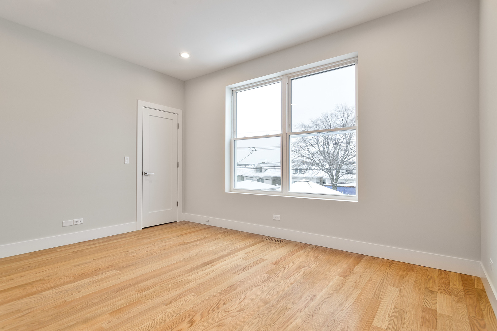 3013 North Normandy Avenue Chicago, IL 60634 - Photo 21 of 26 an empty room with wooden floor and windows