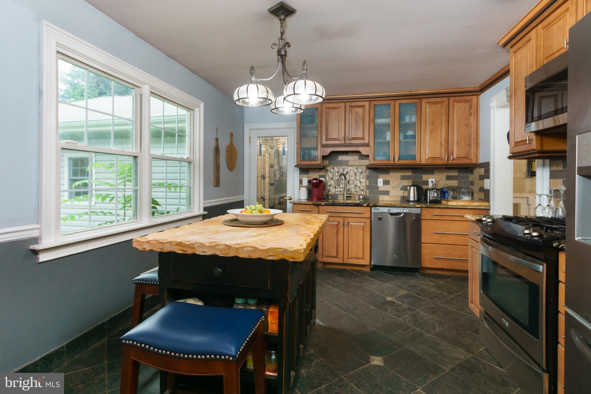 50 Skillman Road Skillman, NJ 08558 - Photo 10 of 31 a kitchen with a stove a sink a kitchen island with chairs and wooden floor