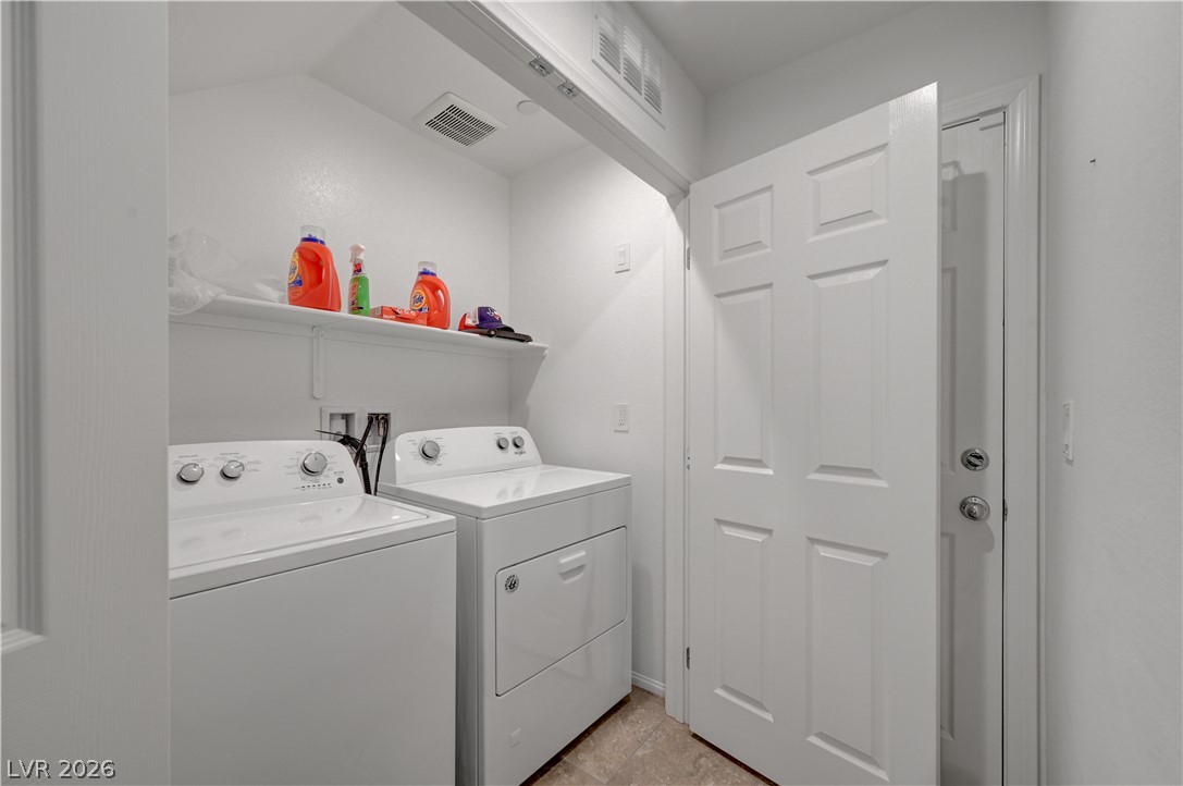 1287 Raritan Place Henderson, NV 89002 - Photo 8 of 21 Functional utility space includes practical shelving and a washer and dryer for household convenience.