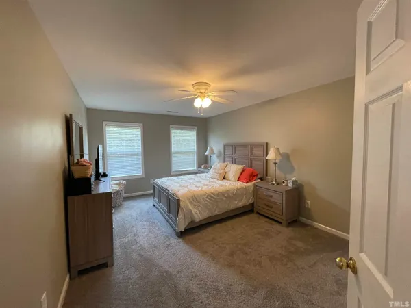 a spacious bedroom with a bed and a chandelier