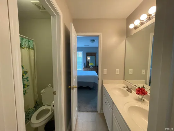 a bedroom with a bed and a flat tv screen on a dresser