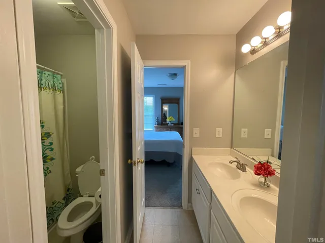 a bedroom with a bed and a flat tv screen on a dresser