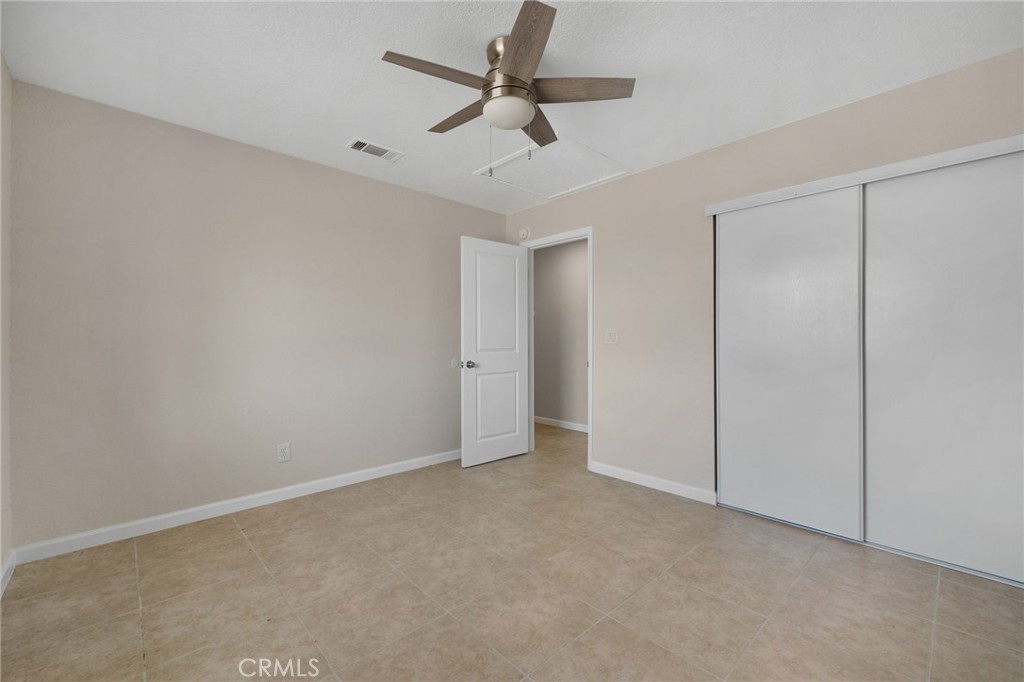 9846 Sunny Vista Road Phelan, CA 92371 - Photo 20 of 34 an empty room with a ceiling fan and a window