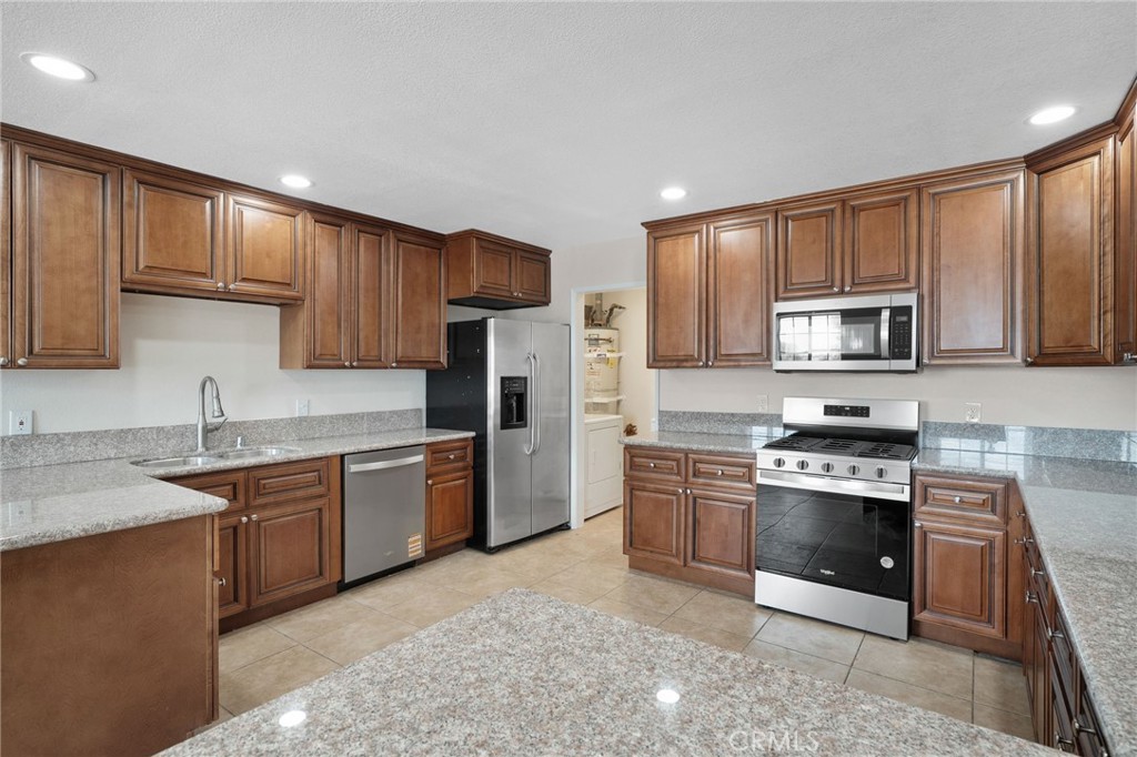 9846 Sunny Vista Road Phelan, CA 92371 - Photo 7 of 34 a kitchen with stainless steel appliances granite countertop a stove sink microwave and refrigerator