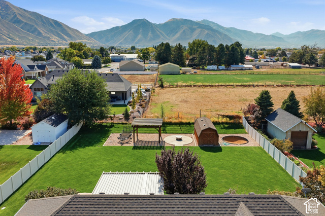 1447 Meadow Lane Mapleton, UT 84664 - Photo 52 of 67 Expansive backyard with a manicured lawn, white vinyl fencing, a detached shed, and a dedicated patio area with a gazebo
