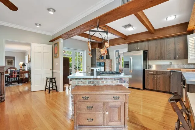 a kitchen with kitchen island a counter top space a sink stainless steel appliances and cabinets