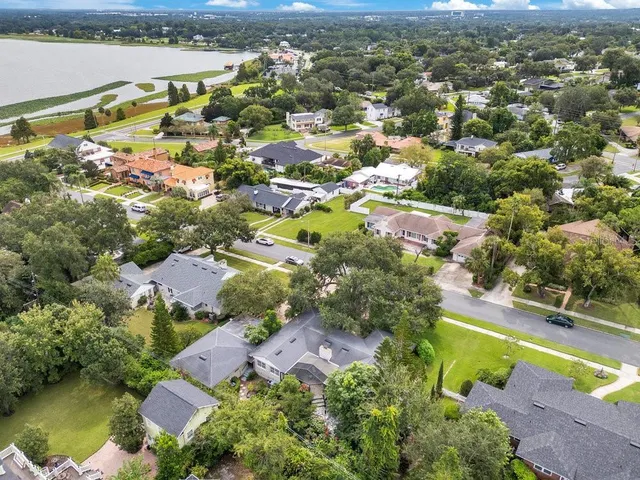 an aerial view of ocean and residential houses with outdoor space