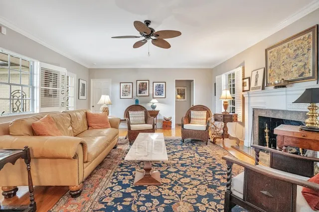 a living room with furniture fireplace and a large window
