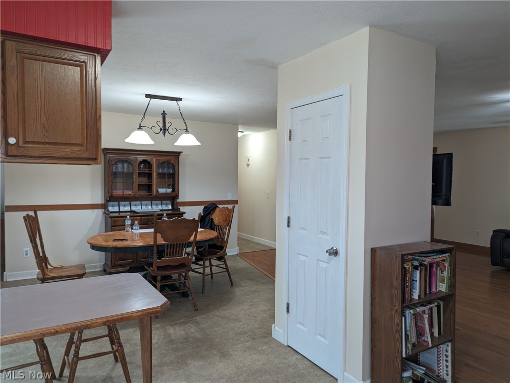 6333 Rochester Road East Rochester, OH 44625 - Photo 24 of 47 Dining room featuring an inviting chandelier and vinyl floors
