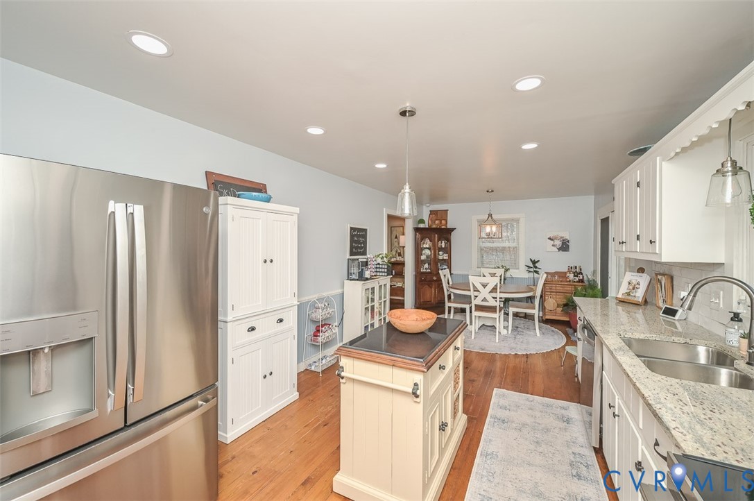 10217 Atlee Station Road Mechanicsville, VA 23116 - Photo 16 of 45 a kitchen with stainless steel appliances a refrigerator a sink dishwasher a stove top oven a dining table and chairs