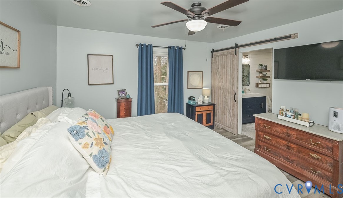 10217 Atlee Station Road Mechanicsville, VA 23116 - Photo 31 of 45 a bedroom with a bed and a flat tv screen on dresser