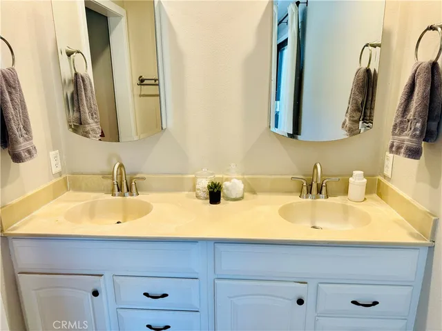 a bathroom with double vanity sinks and a mirror