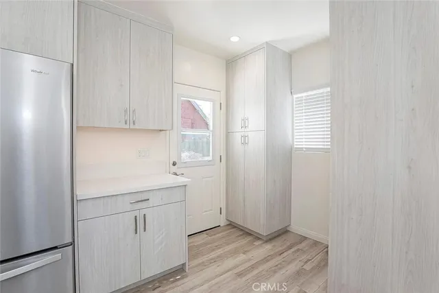 a kitchen with a refrigerator a stove top oven and wooden floor