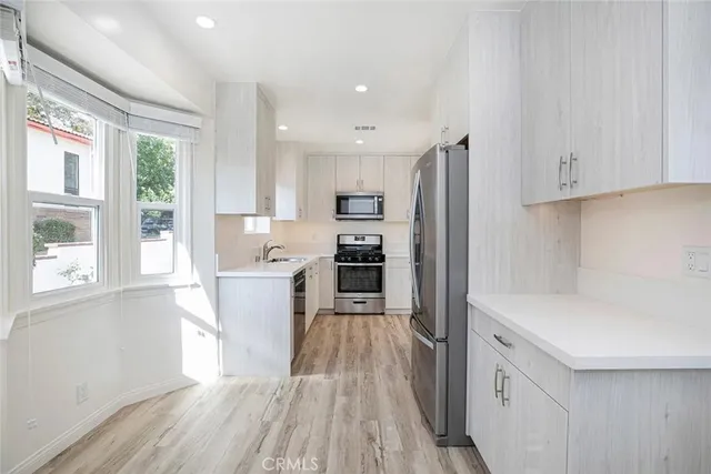 a kitchen with a sink cabinets appliances and a window