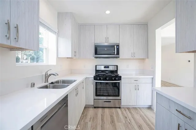 a kitchen with white cabinets and stainless steel appliances