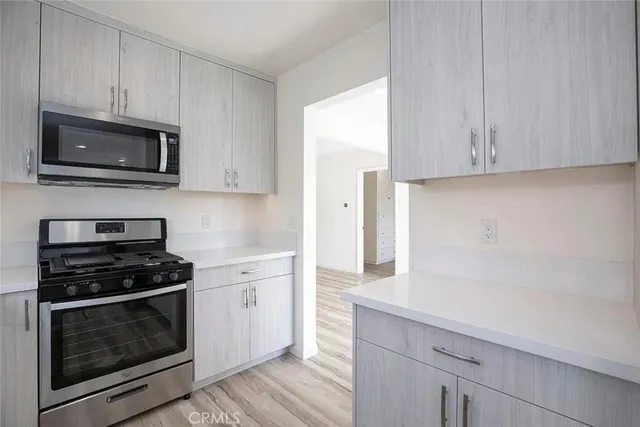 a kitchen with stainless steel appliances a refrigerator a stove a microwave and cabinets