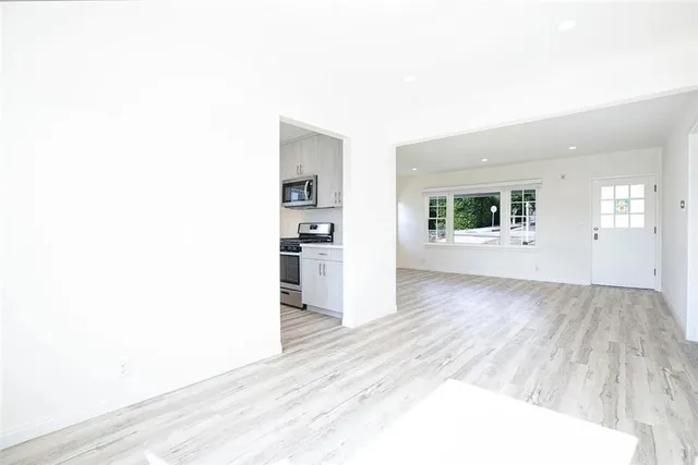 a view of an empty room with wooden floor