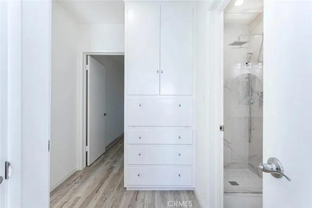 a view of a room with wooden floor closet and windows