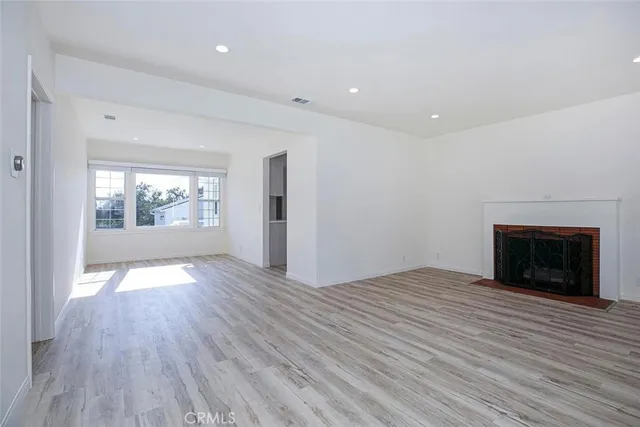 an empty room with windows and fireplace
