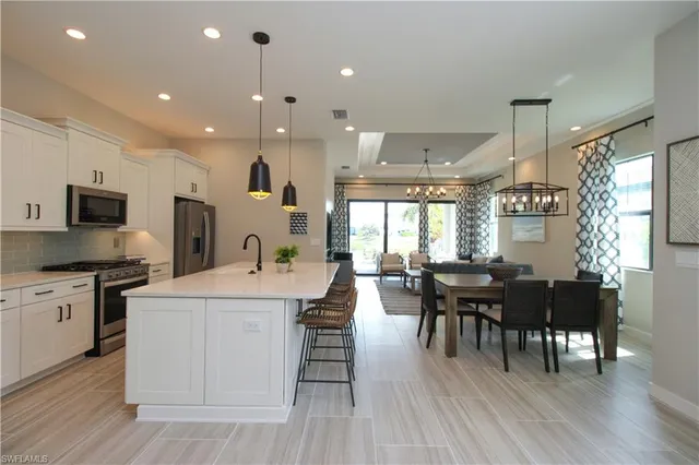 a living room with stainless steel appliances kitchen island granite countertop furniture wooden floor and a view of kitchen