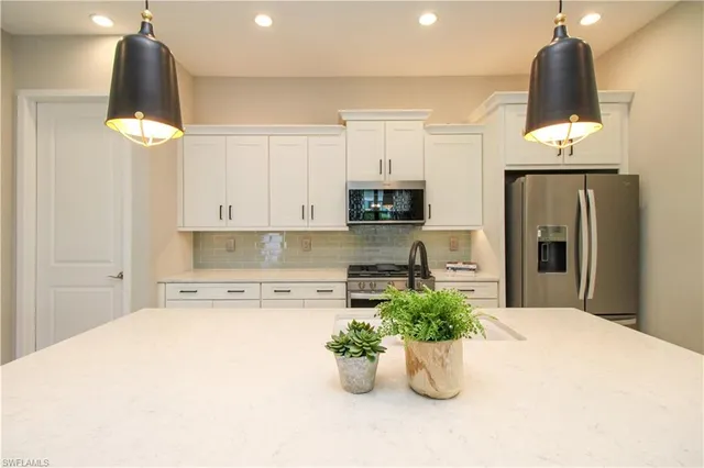 a kitchen with a refrigerator and a white cabinets