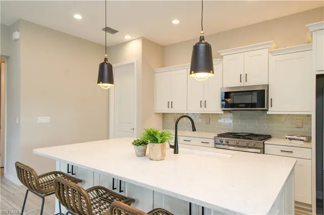 a kitchen with stainless steel appliances kitchen island a refrigerator and a stove top oven