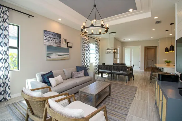 a living room with furniture a dining table and a chandelier