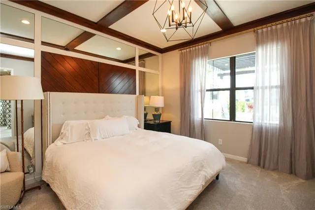 a bedroom with a large bed and a chandelier