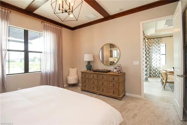 a bedroom with a bed mirror and a window