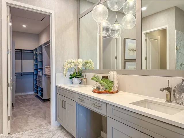 a bathroom with a sink a potted plant and a mirror