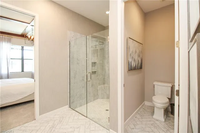 a bathroom with a toilet and a shower