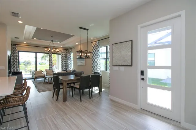 a dining room with furniture a chandelier and wooden floor