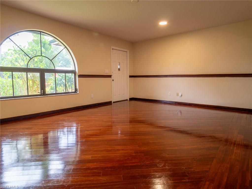 18414 Tulip Road Fort Myers, FL 33967 - Photo 5 of 37 Room featuring wood flooring, a half-round transom window, recessed lighting, and a white paneled door