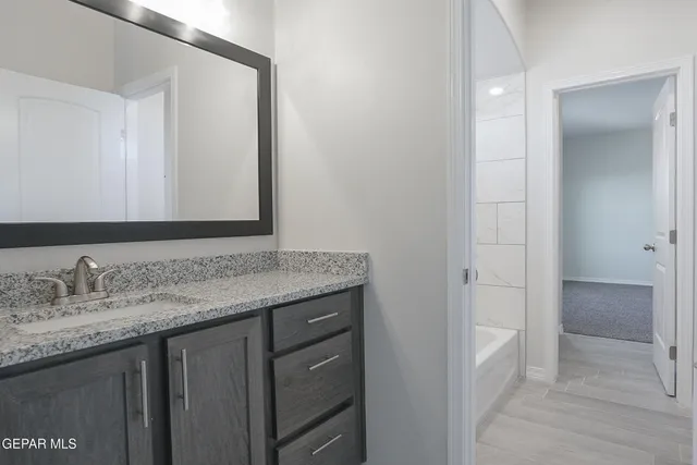 a bathroom with a granite countertop sink and a mirror