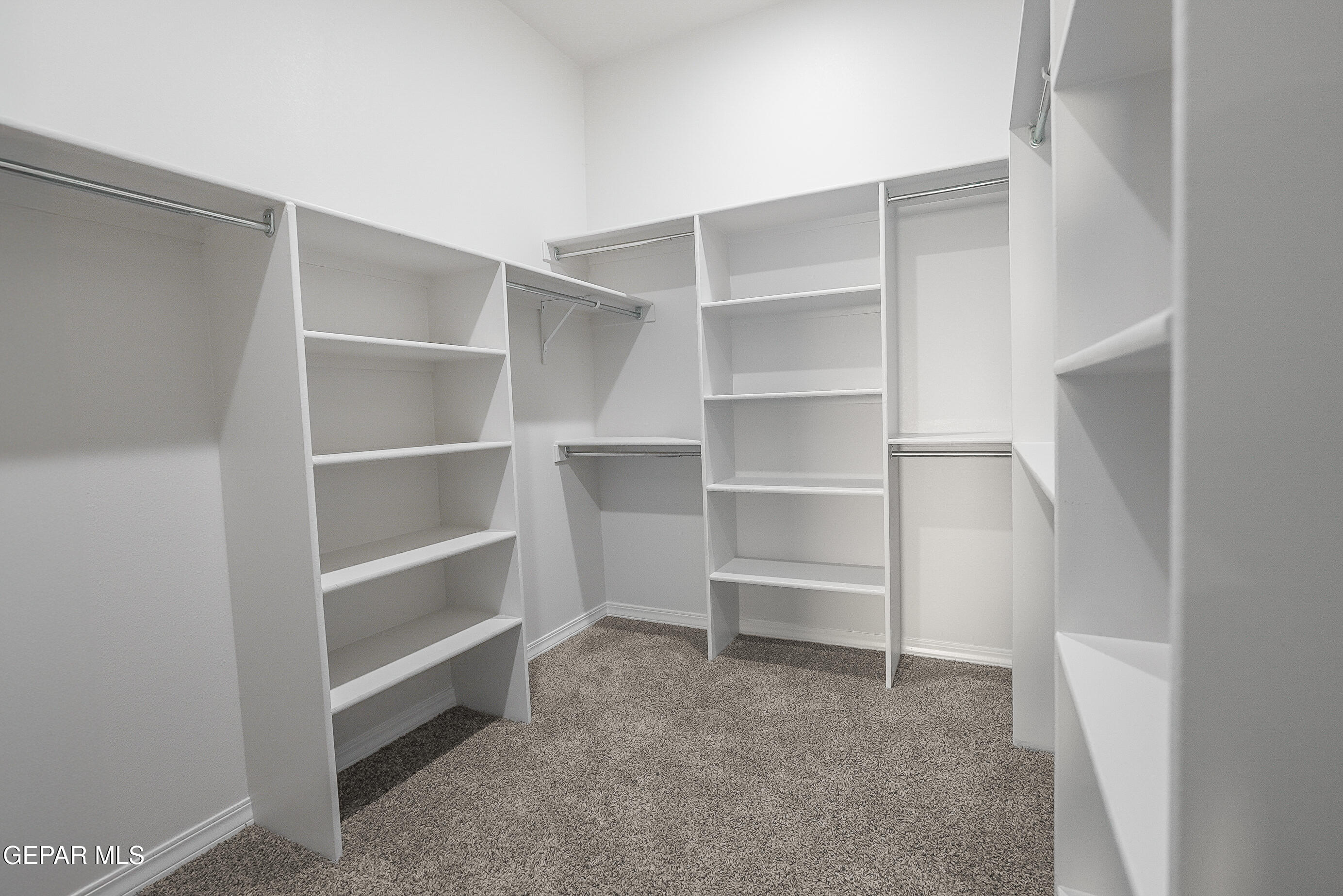 12436 Fill Ball Street El Paso, TX 79928 - Photo 27 of 31 a view of walk in closet with empty racks
