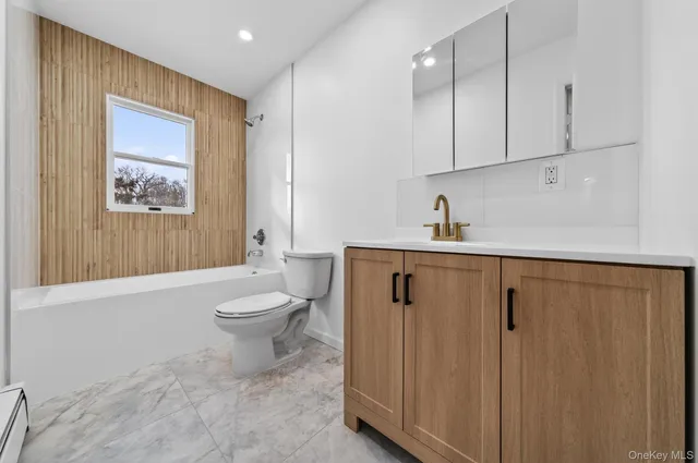 a bathroom with a granite countertop sink a toilet and shower