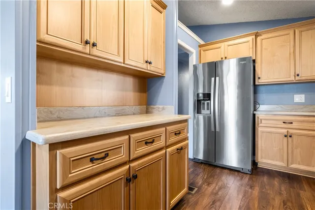 a kitchen with granite countertop a refrigerator stove and wooden floor