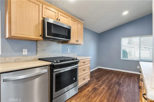 a kitchen with stainless steel appliances a stove microwave and sink