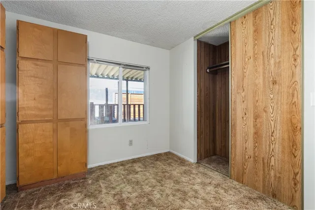 a view of an empty room with window and stairs