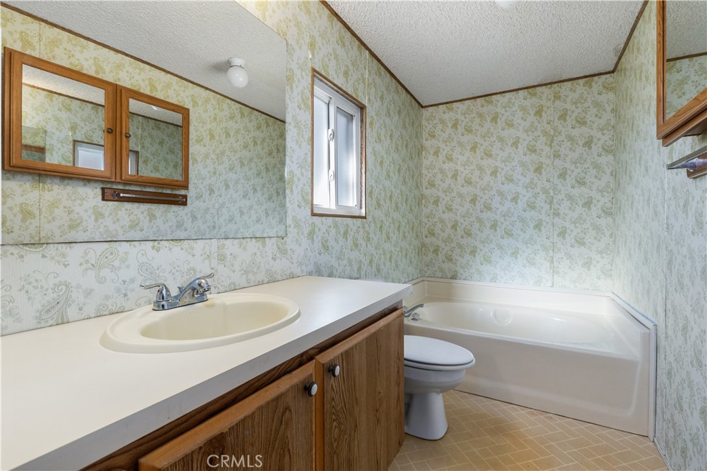 1220 Bennett Way, Unit 1 Templeton, CA 93465 - Photo 28 of 37 a bathroom with a sink a toilet and a large mirror