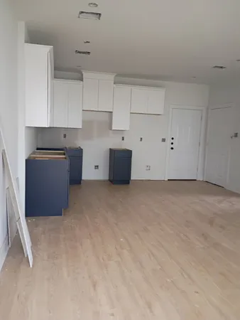a kitchen with cabinets and wooden floor