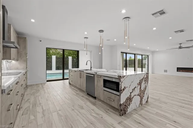 a kitchen with stainless steel appliances granite countertop a stove a sink and a refrigerator