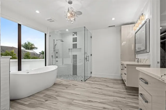 a large spacious bathroom with a double vanity sink a large mirror and shower