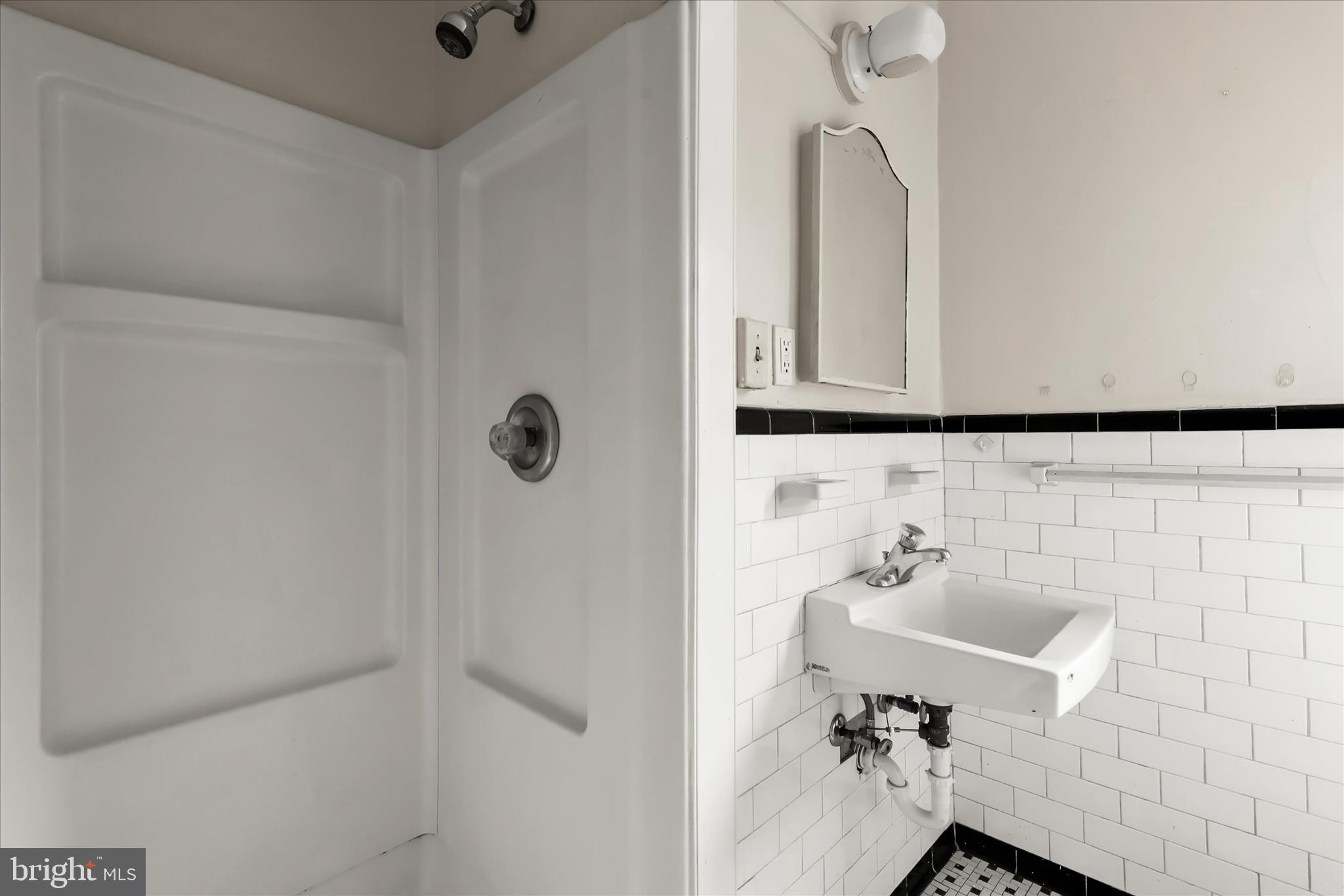3511 6th Street Baltimore, MD 21225 - Photo 24 of 31 a bathroom with a sink and mirror