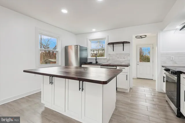 a kitchen with stainless steel appliances granite countertop a sink refrigerator stove and microwave