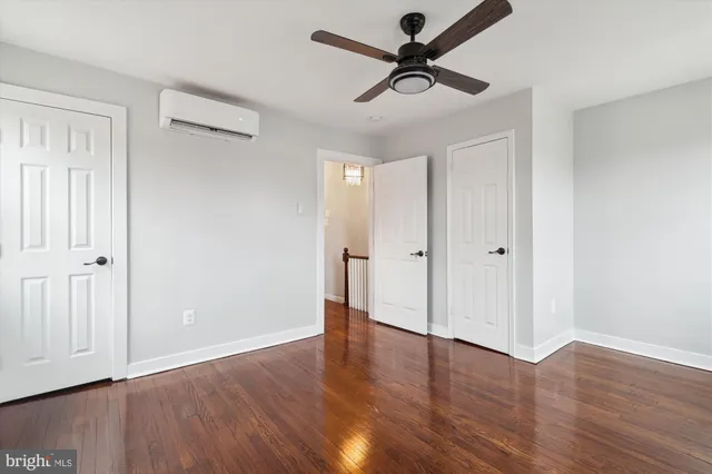 a view of a room with wooden floor and a ceiling fan